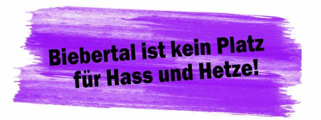 Ein Marginaltext zeigt einen breiten Pinselstrich in Blauviolett mit dem Text in schwarzer Farbe: Biebertal kein Platz für Hass und Hetze