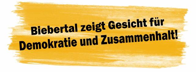 Ein Marginaltext zeigt einen breiten Pinselstrich in Gelb mit dem Text in schwarzer Farbe: Biebertal zeigt Gessicht für Demokatie und Zusammenhalt.