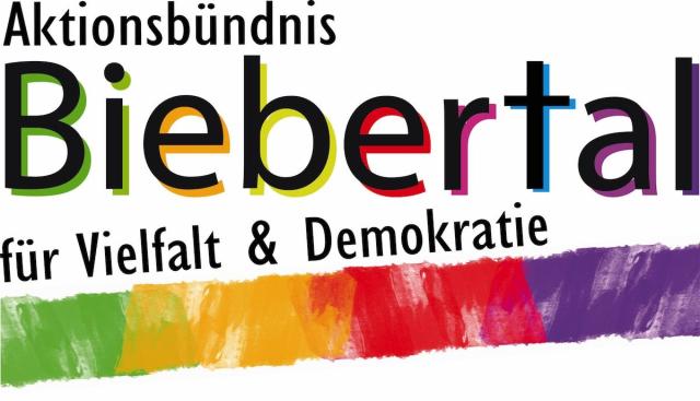Es ist das bunt gestaltete Logo des Aktionsbündnisses zu sehen: Weißer Grund, Regenbogenfarben, schwarze Schrift: Aktionsbündnis Biebertal für Vielfalt und Demokratie.