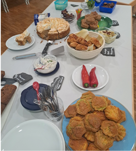 Ein Tisch mit verschiedenen mitgebrachten Snacks, Fingerfood und Gebäck während einer Pause des Workshops.