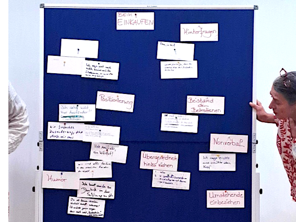 Eine Pinnwand im Workshop, an der zahlreiche bunte Ideenzettel aus dem Brainstorming gesammelt sind.