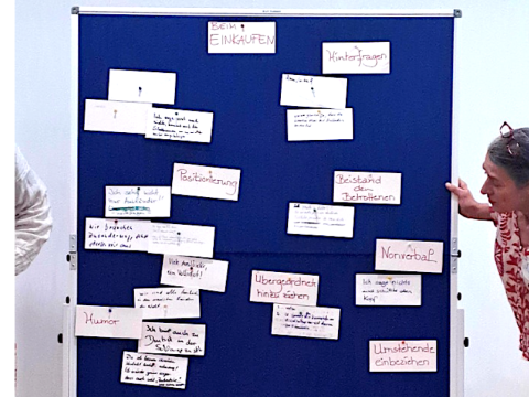 Eine Pinnwand im Workshop, an der zahlreiche bunte Ideenzettel aus dem Brainstorming gesammelt sind.